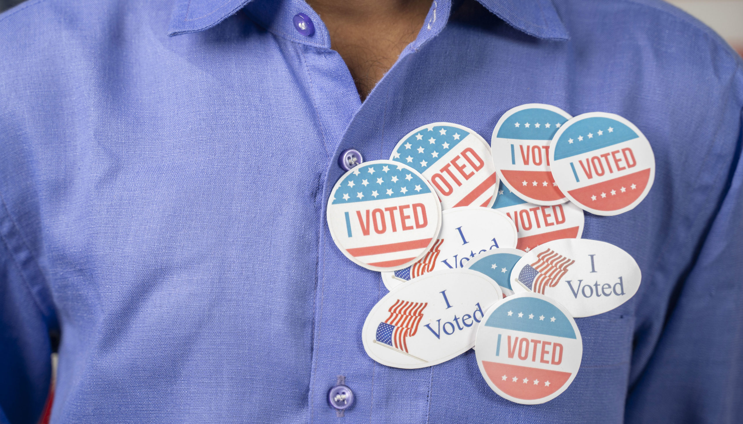 Close up of multiple I Voted stickers on blue shirt